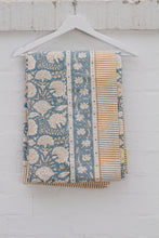 Load image into Gallery viewer, Blue and beige patterned tablecloth hanging on a white hanger against a light wooden panel background.
