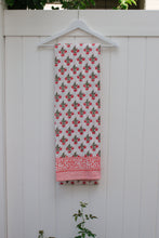 Load image into Gallery viewer, Pink and white patterned tablecloth hanging on a white wooden fence.