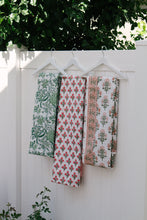 Load image into Gallery viewer, Three floral-patterned cloths hanging on a white wooden fence with greenery in the background.