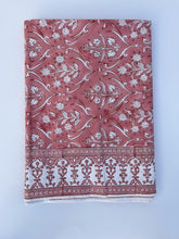 Load image into Gallery viewer, Folded tablecloth with a floral pattern in peach, pink, and white colors.